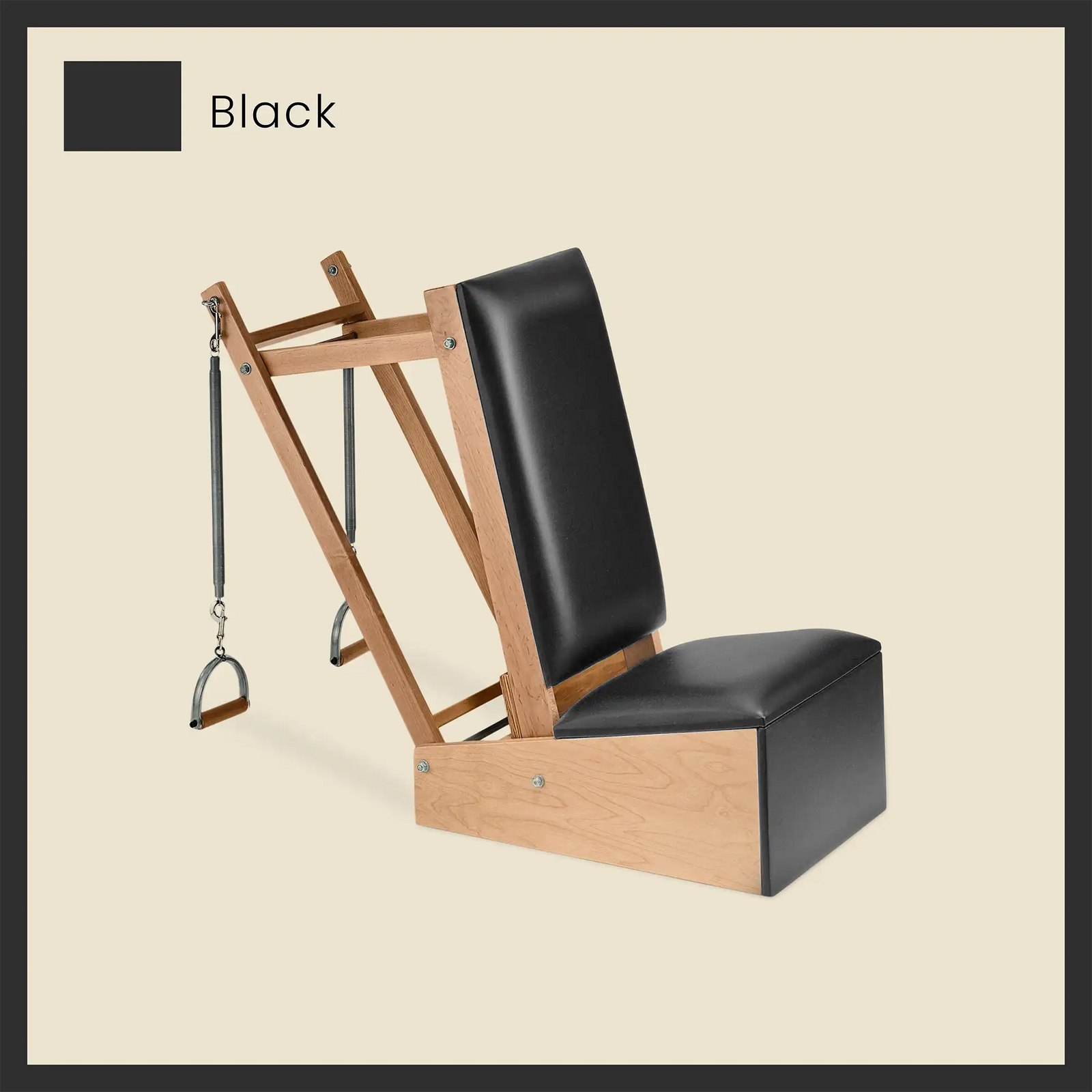 Black Pilates arm chair featuring black vinyl padding, wooden frame, and attached spring-loaded handles.