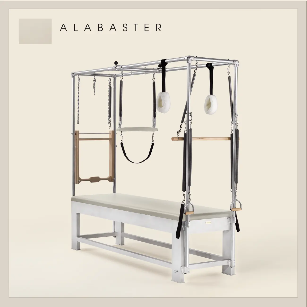Alabaster color Trapeze Table with aluminum frame, adjustable bars, straps, and springs. Premium Pilates equipment against a beige background.