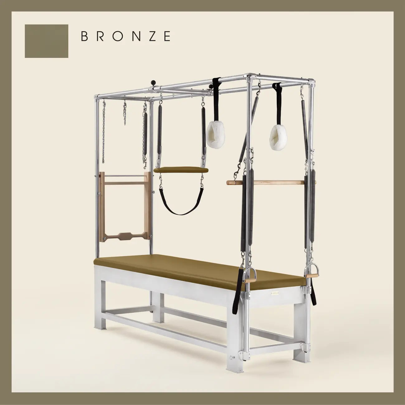 Bronze color Trapeze Table with aluminum frame, adjustable bars, straps, and springs. Premium Pilates equipment against a beige background.
