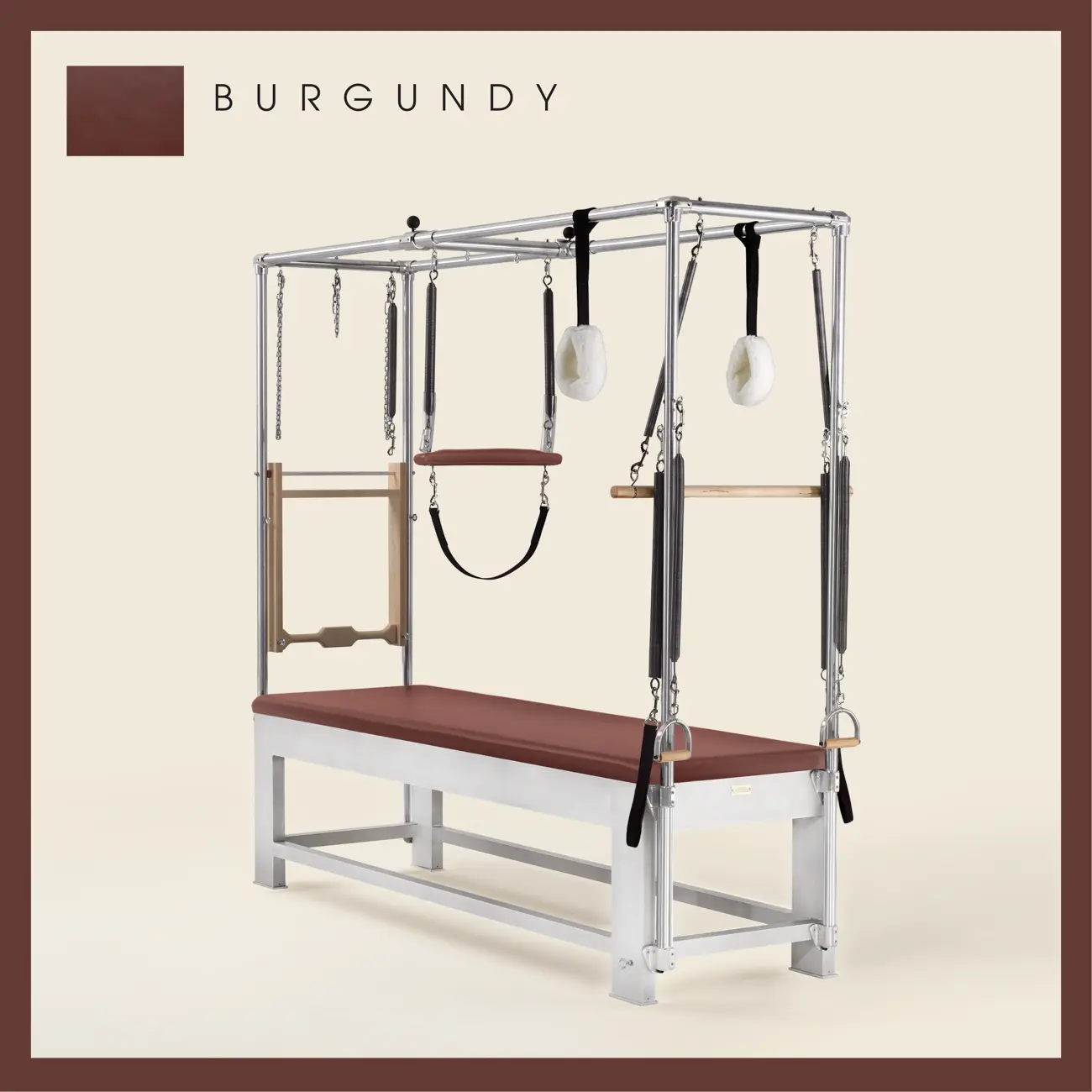 Burgundy color Trapeze Table with aluminum frame, adjustable bars, straps, and springs. Premium Pilates equipment against a beige background.