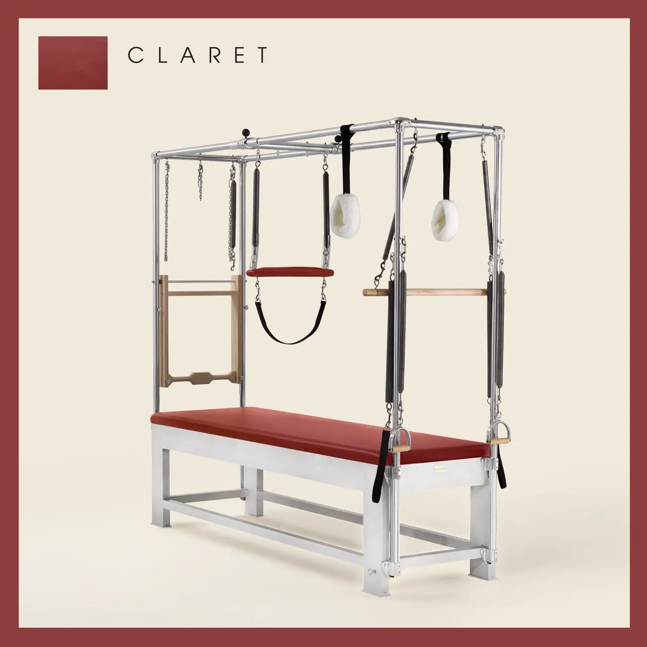 Claret color Trapeze Table with aluminum frame, adjustable bars, straps, and springs. Premium Pilates equipment against a beige background.