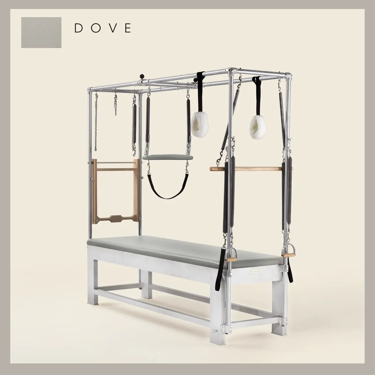 Dove color Trapeze Table with aluminum frame, adjustable bars, straps, and springs. Premium Pilates equipment against a beige background.