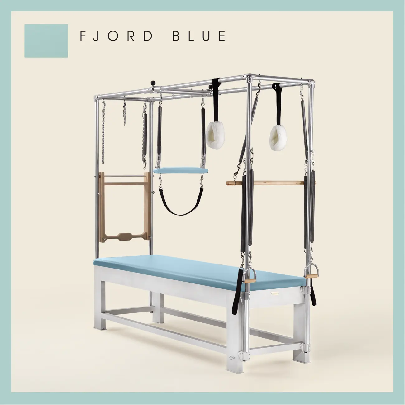 Fjord Blue color Trapeze Table with aluminum frame, adjustable bars, straps, and springs. Premium Pilates equipment against a beige background.