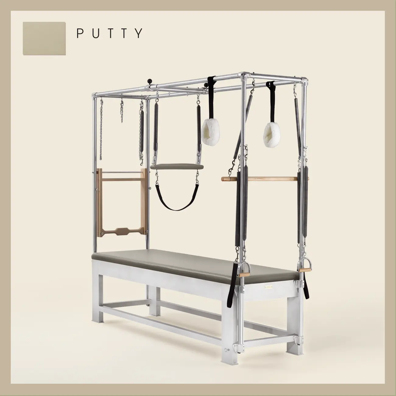 Putty color Trapeze Table with aluminum frame, adjustable bars, straps, and springs. Premium Pilates equipment against a beige background.