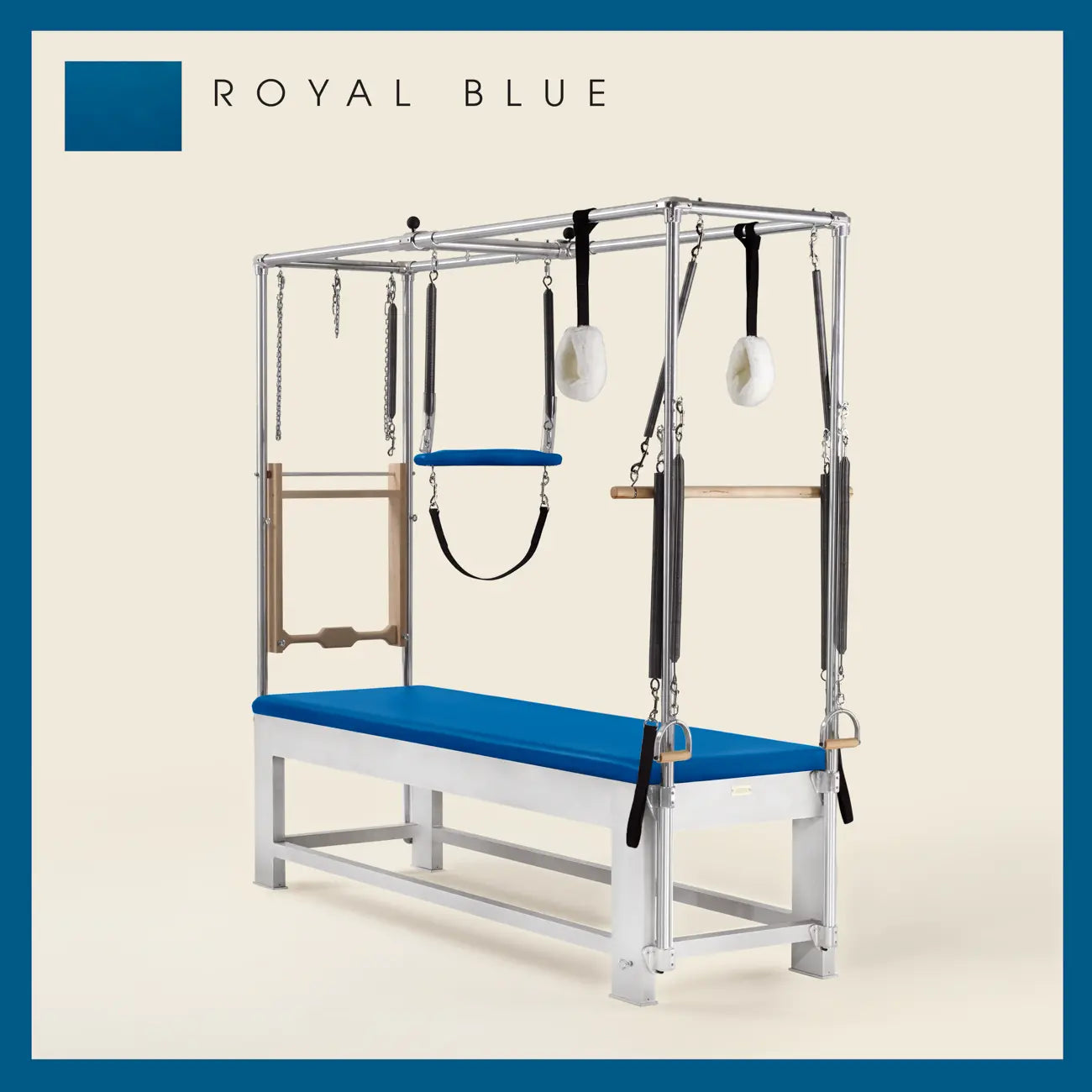 Royal blue color Trapeze Table with aluminum frame, adjustable bars, straps, and springs. Premium Pilates equipment against a beige background.