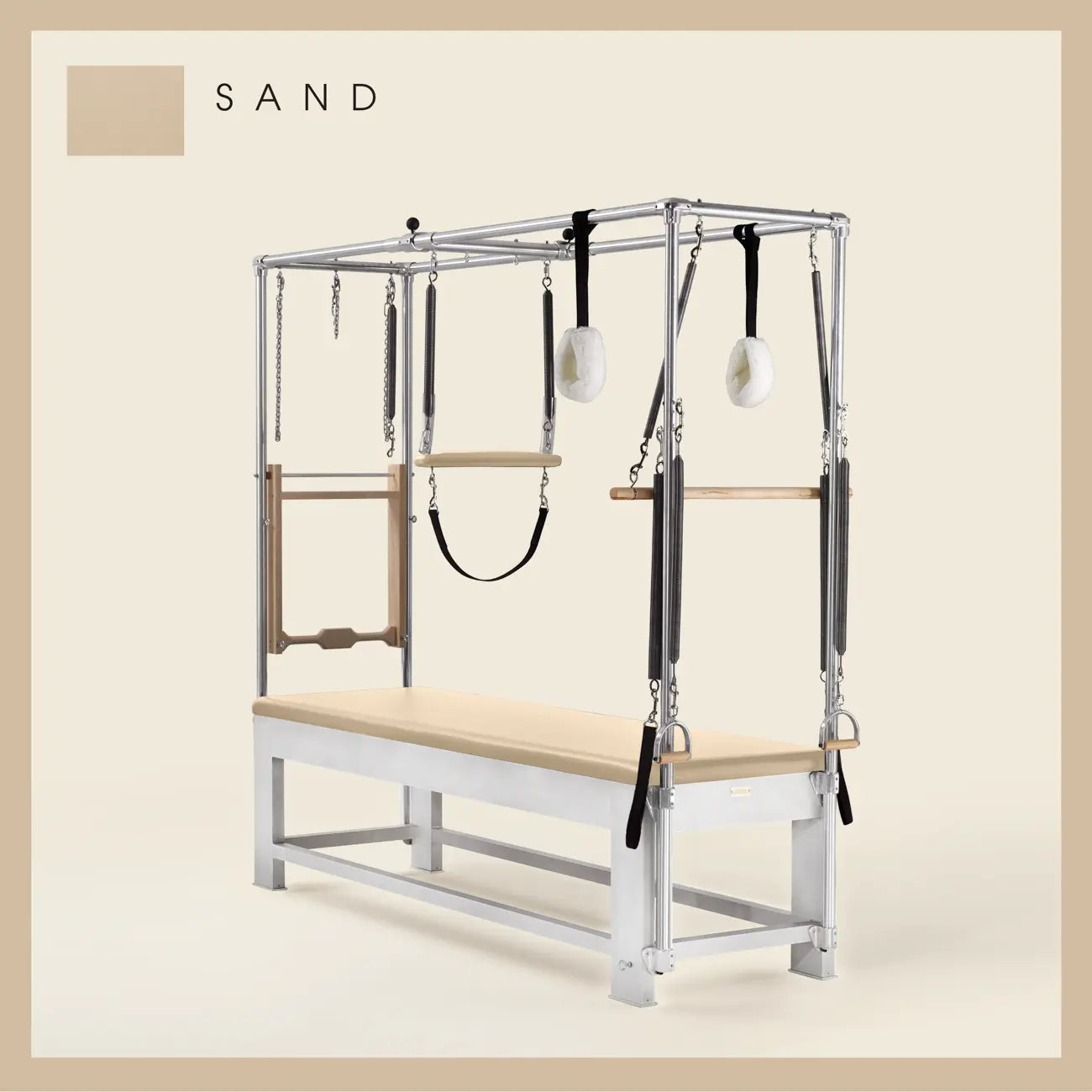 Sand color Trapeze Table with aluminum frame, adjustable bars, straps, and springs. Premium Pilates equipment against a beige background.