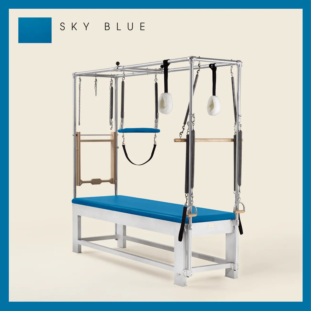 Sky blue color Trapeze Table with aluminum frame, adjustable bars, straps, and springs. Premium Pilates equipment against a beige background.