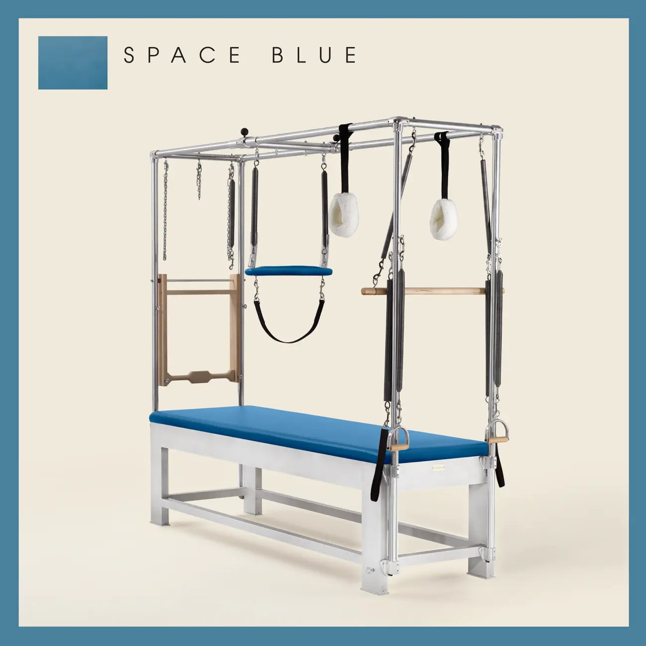 Space Blue color Trapeze Table with aluminum frame, adjustable bars, straps, and springs. Premium Pilates equipment against a beige background.