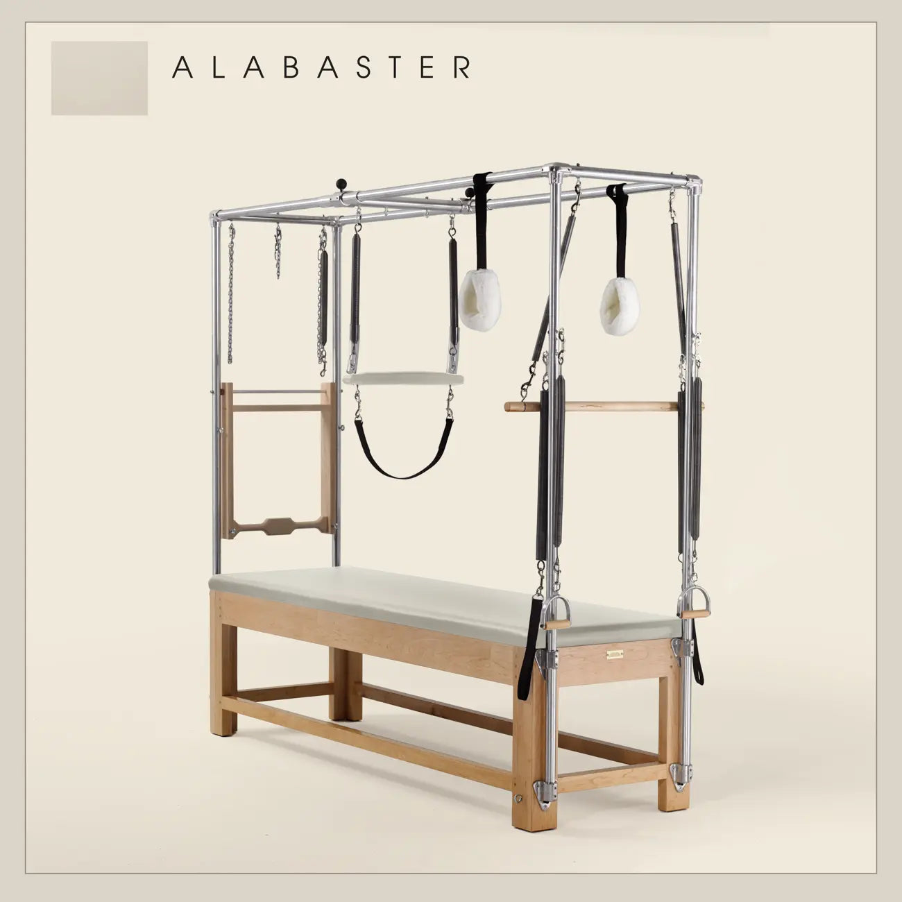 Alabaster color Pilates Cadillac with maple wood frame, adjustable bars, straps, and springs. Premium Pilates equipment against a beige background.