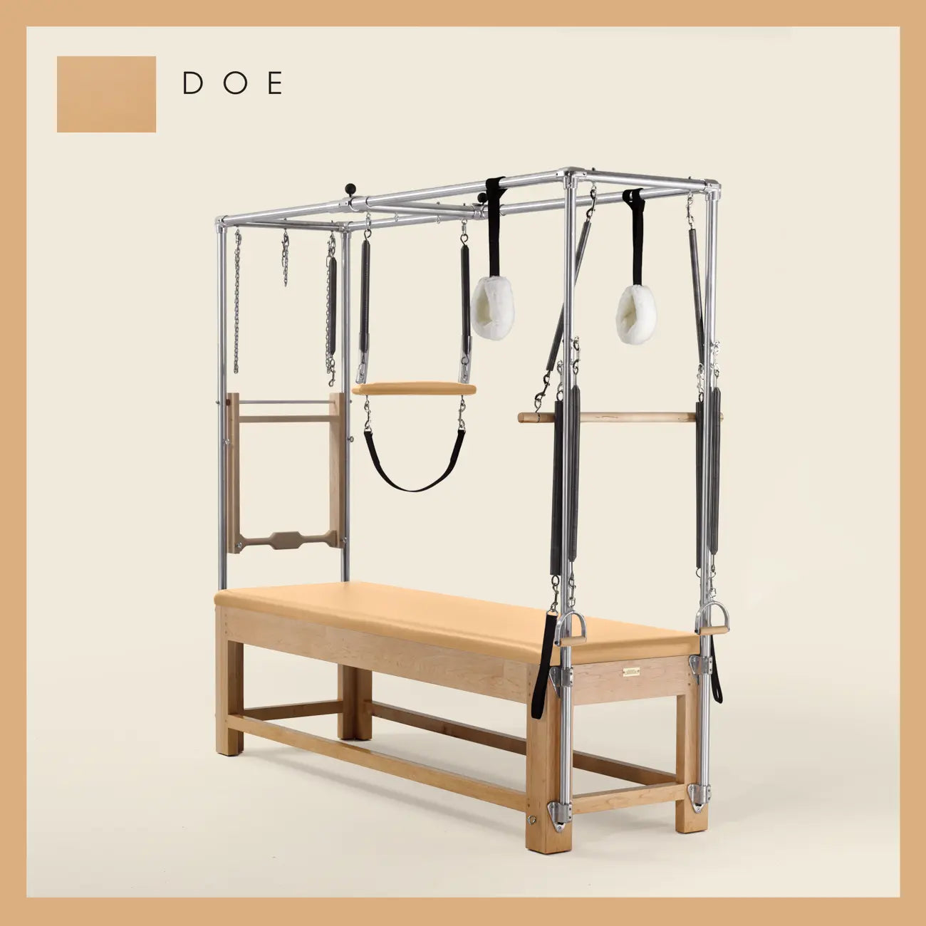 Doe color Pilates Cadillac with maple wood frame, adjustable bars, straps, and springs. Premium Pilates equipment against a beige background.