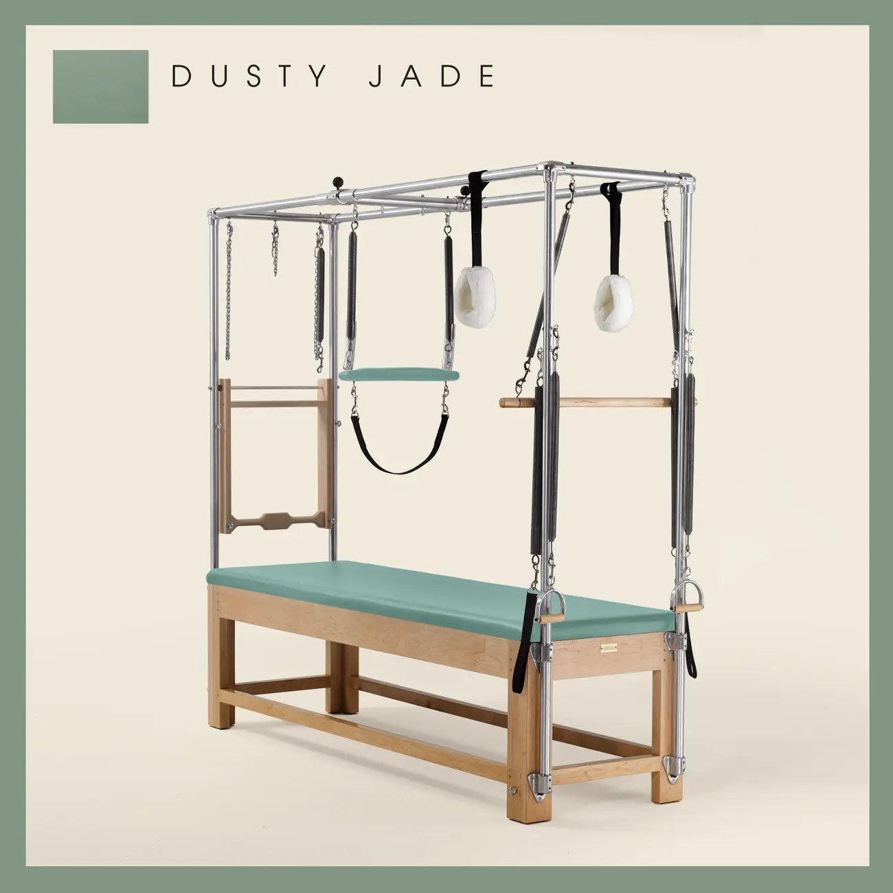 Dusty Jade Pilates Cadillac with maple wood frame, adjustable bars, straps, and springs. Premium Pilates equipment against a beige background.