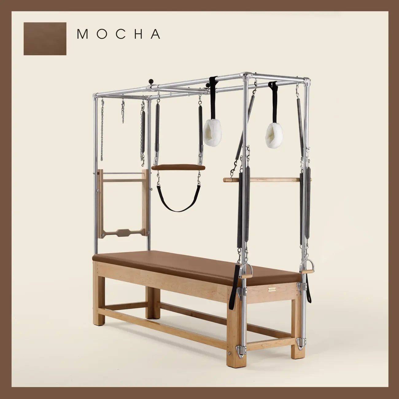 Mocha Pilates Cadillac with maple wood frame, adjustable bars, straps, and springs. Premium Pilates equipment against a beige background.