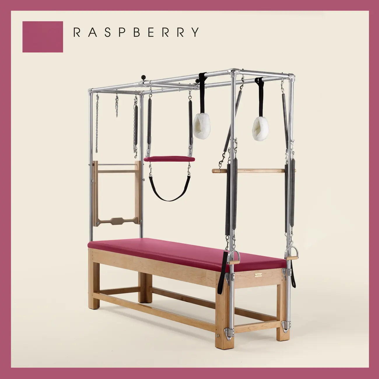 Raspberry Pilates Cadillac with maple wood frame, adjustable bars, straps, and springs. Premium Pilates equipment against a beige background.