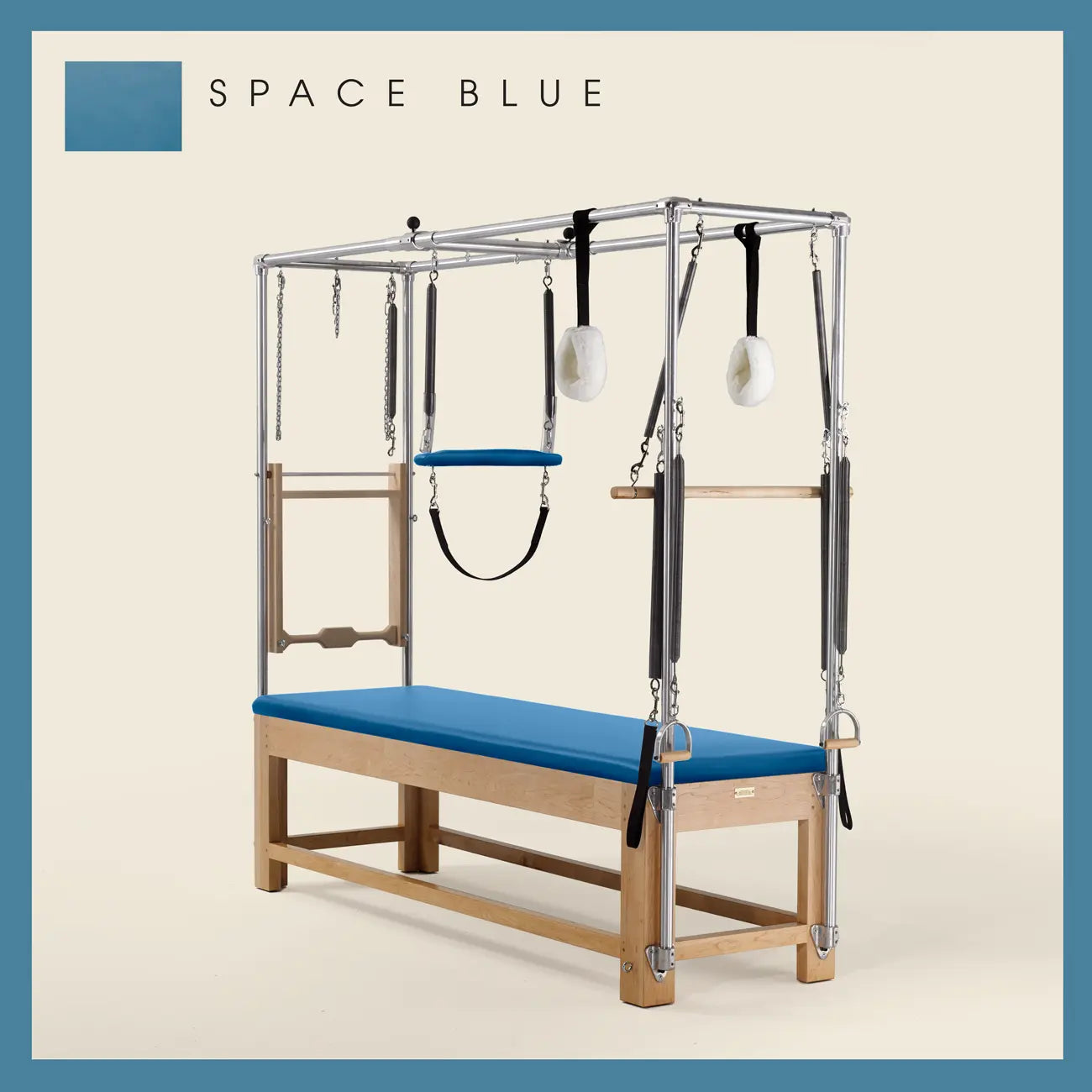 Space Blue Pilates Cadillac with maple wood frame, adjustable bars, straps, and springs. Premium Pilates equipment against a beige background.