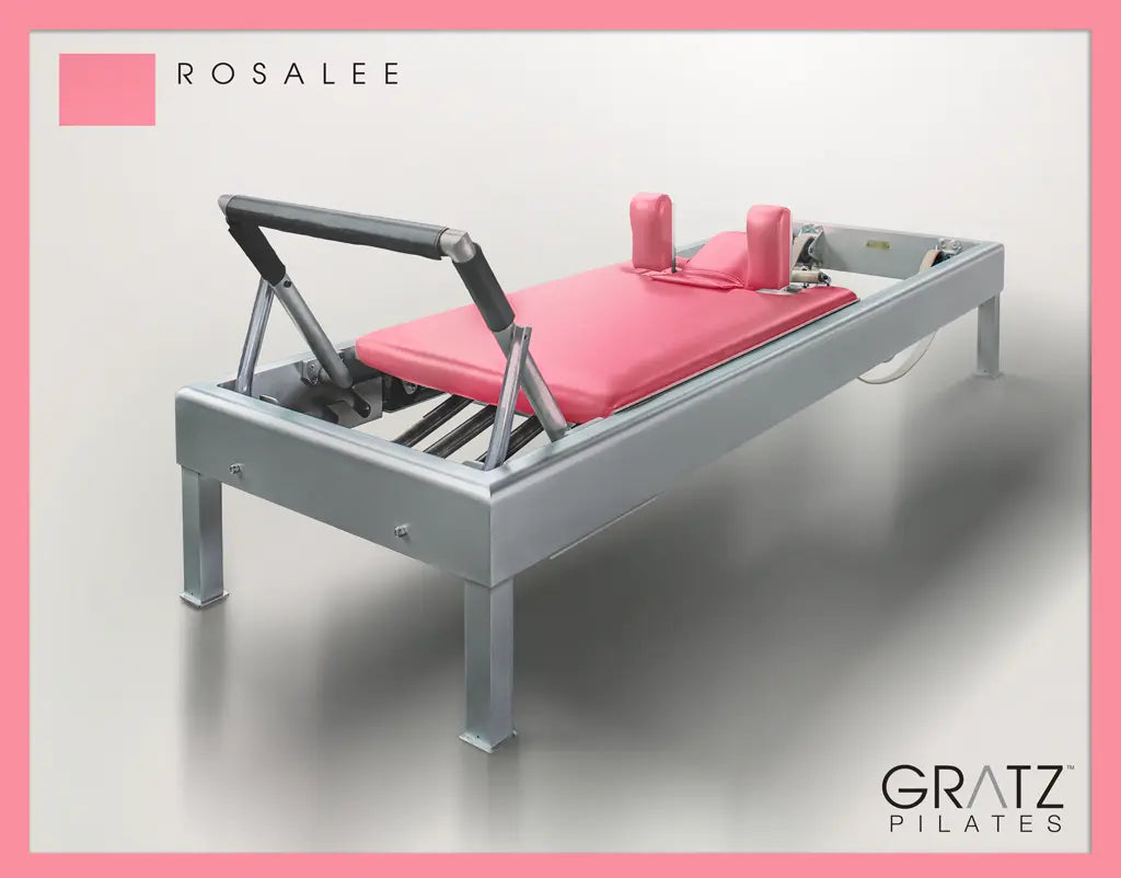 Gratz Pilates Aluminum Archive Reformer Equipment in Rosalee color Padded Carriage.  Soft beige background.