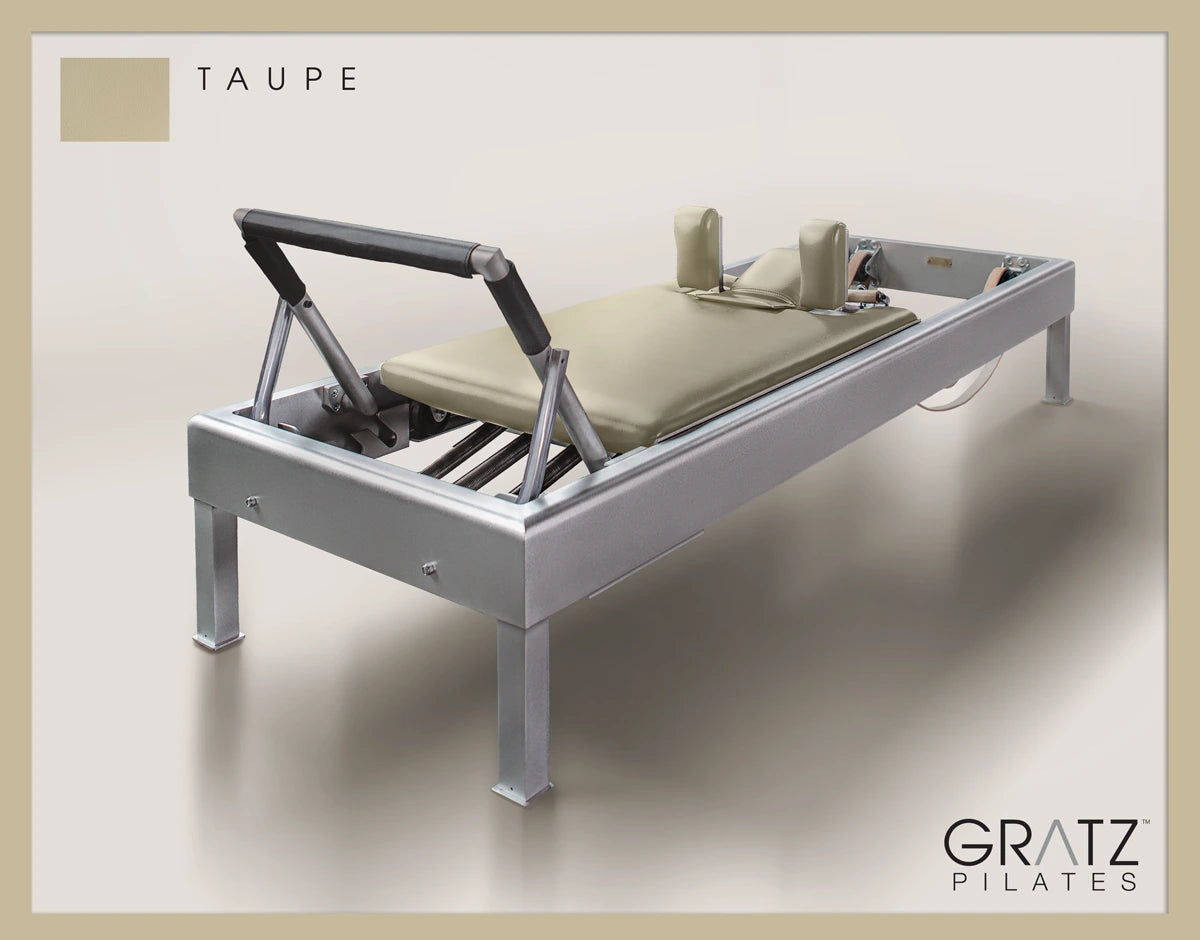 Gratz Pilates Aluminum Archive Reformer Equipment in Taupe color Padded Carriage.  Soft beige background.
