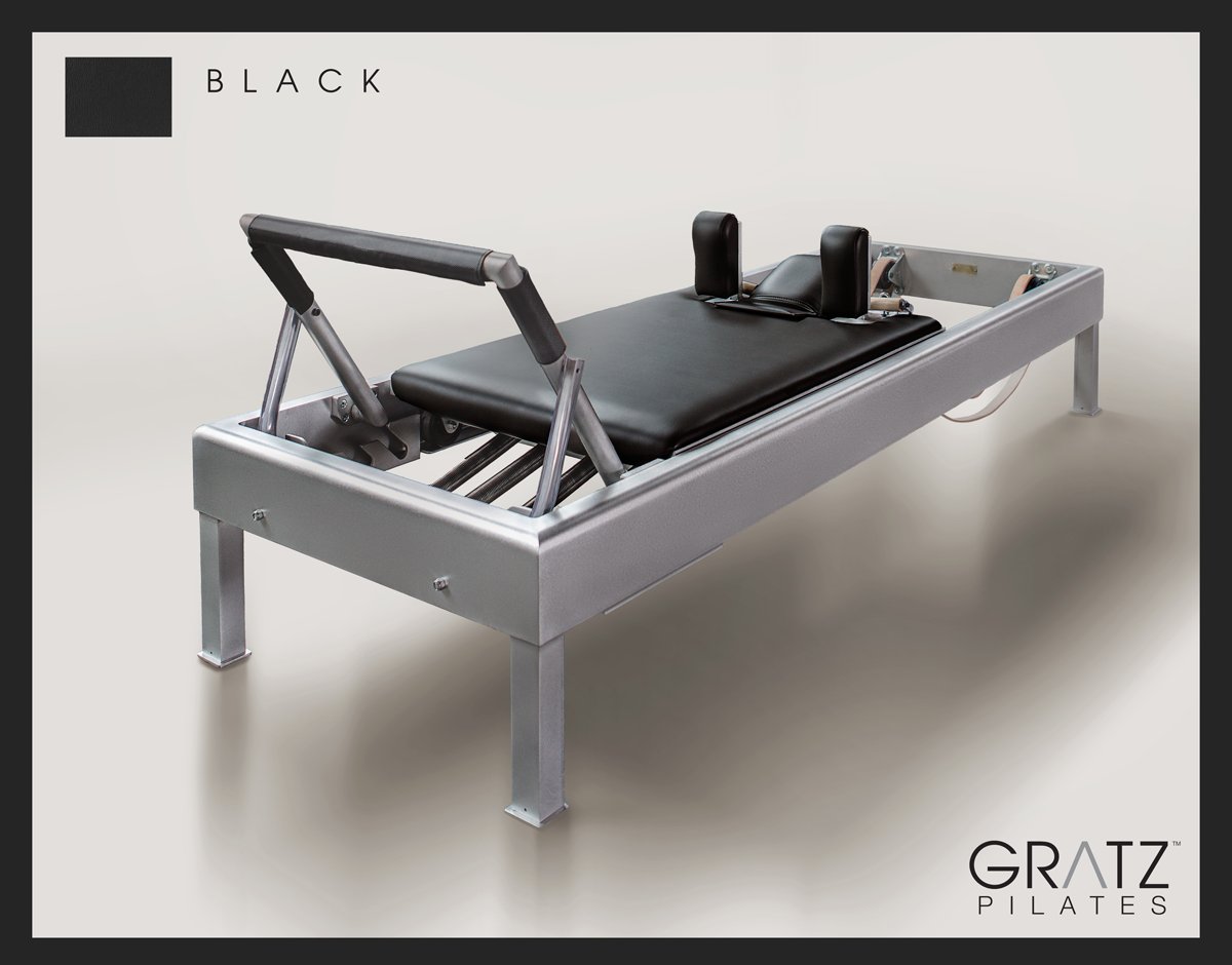 Gratz Pilates Aluminum Archive Reformer Equipment with Black color Padded Carriage.  Soft beige background.