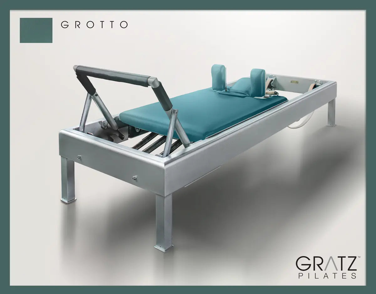 Gratz Pilates Aluminum Archive Reformer Equipment in Grotto color Padded Carriage. Soft beige background.