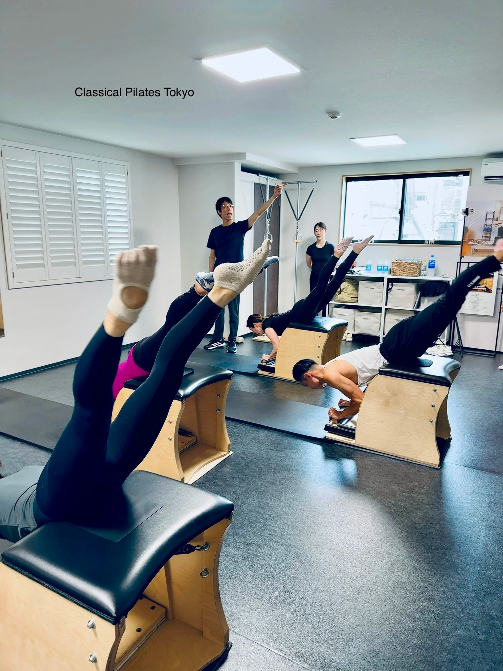 Classical Pilates teacher Kohei Ichikawa teaching clients with Gratz apparatus in his studio