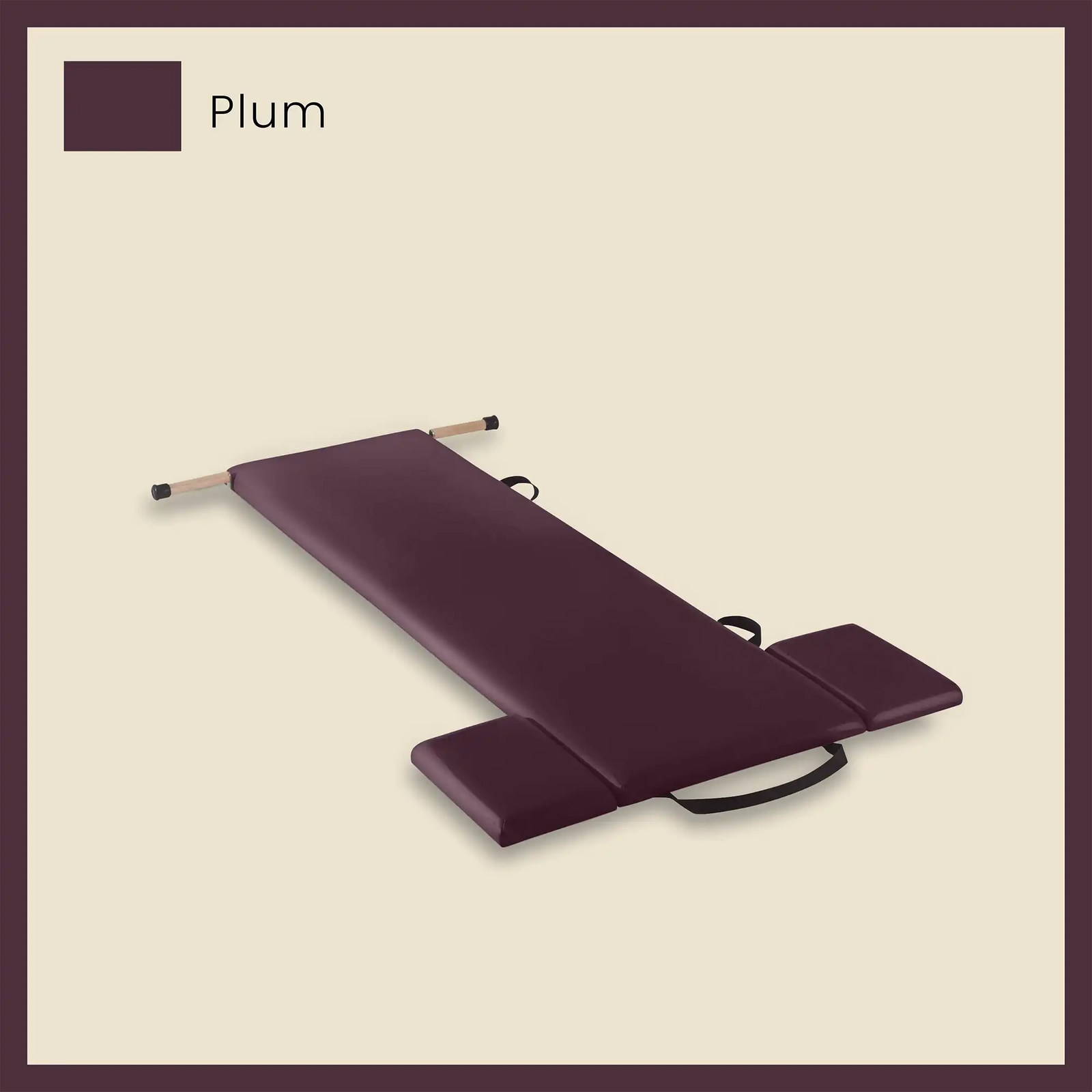 Pilates mat in plum color with side cushions and foot strap on a neutral beige background.
