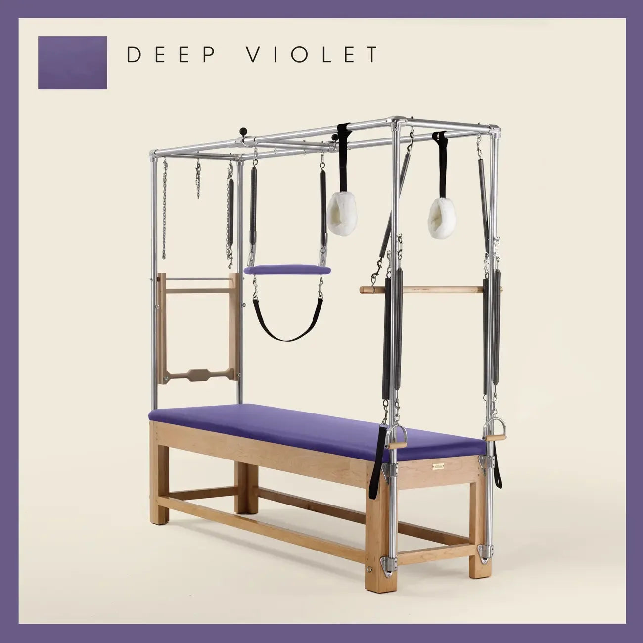 Deep Violet Pilates Cadillac with maple wood frame, adjustable bars, straps, and springs. Premium Pilates equipment against a beige background.