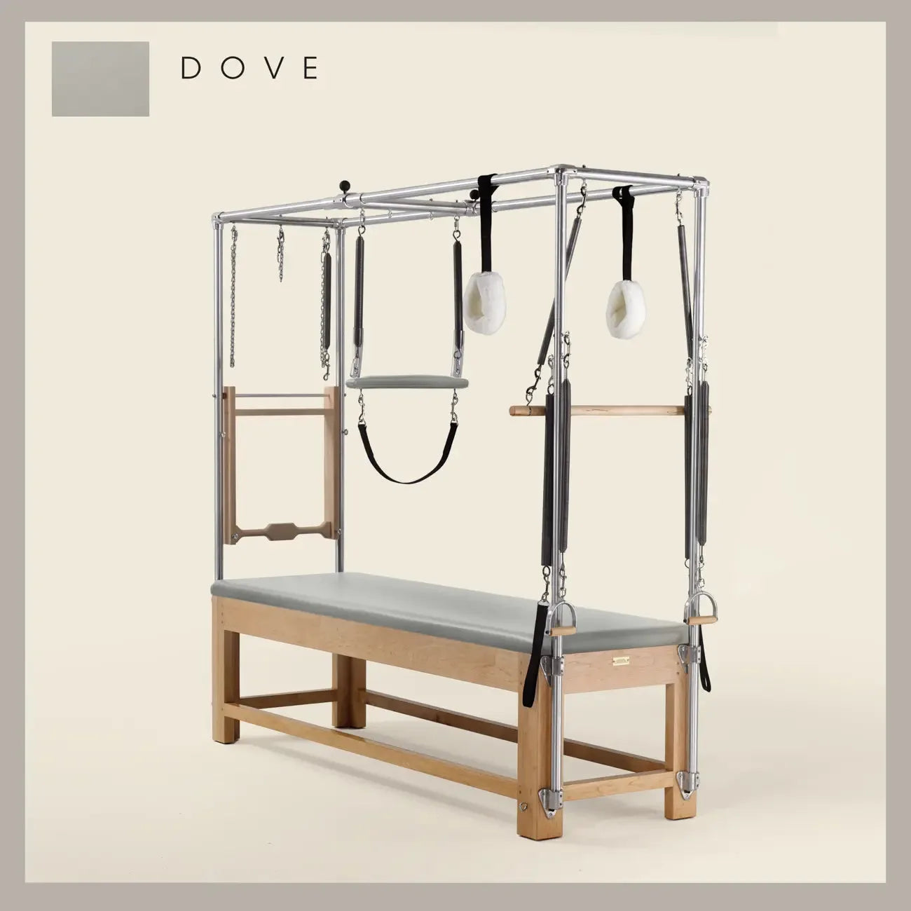 Dove color Pilates Cadillac with maple wood frame, adjustable bars, straps, and springs. Premium Pilates equipment against a beige background.