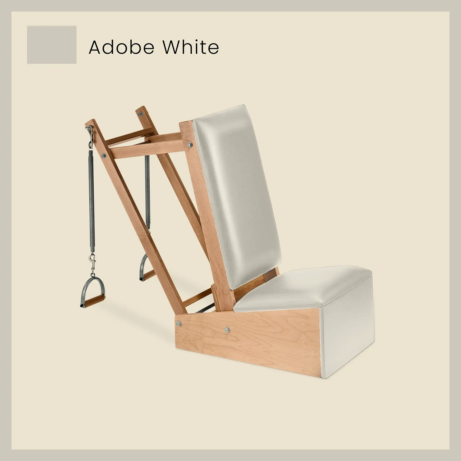White Pilates arm chair with light-toned vinyl cushions and wooden frame for spring-based exercises.
