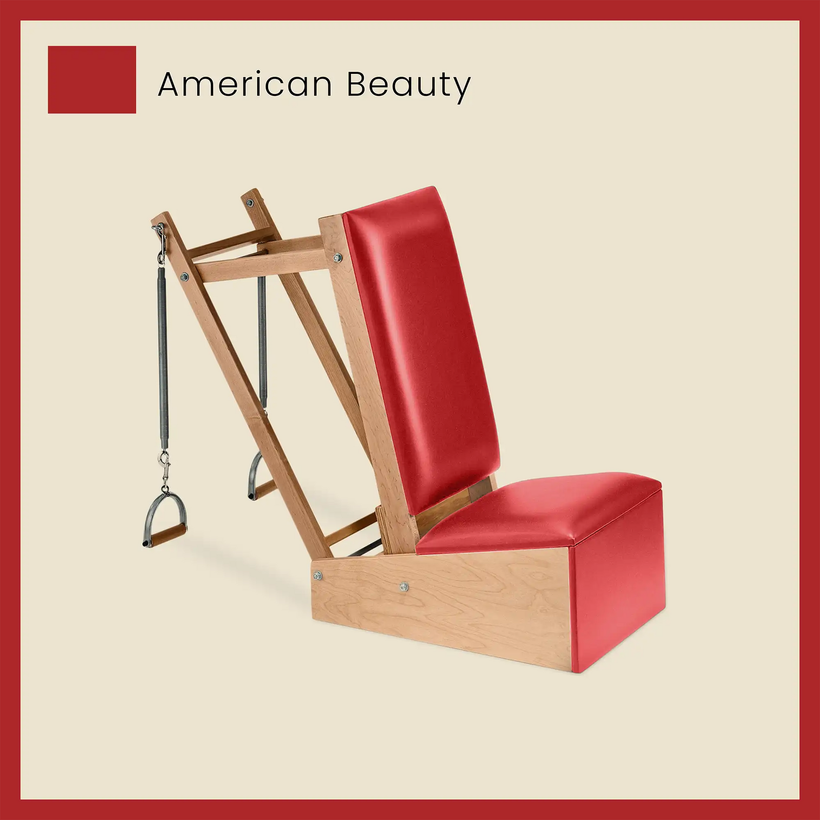 Red Pilates arm chair with vibrant American Beauty upholstery and wooden frame for resistance-based exercises.