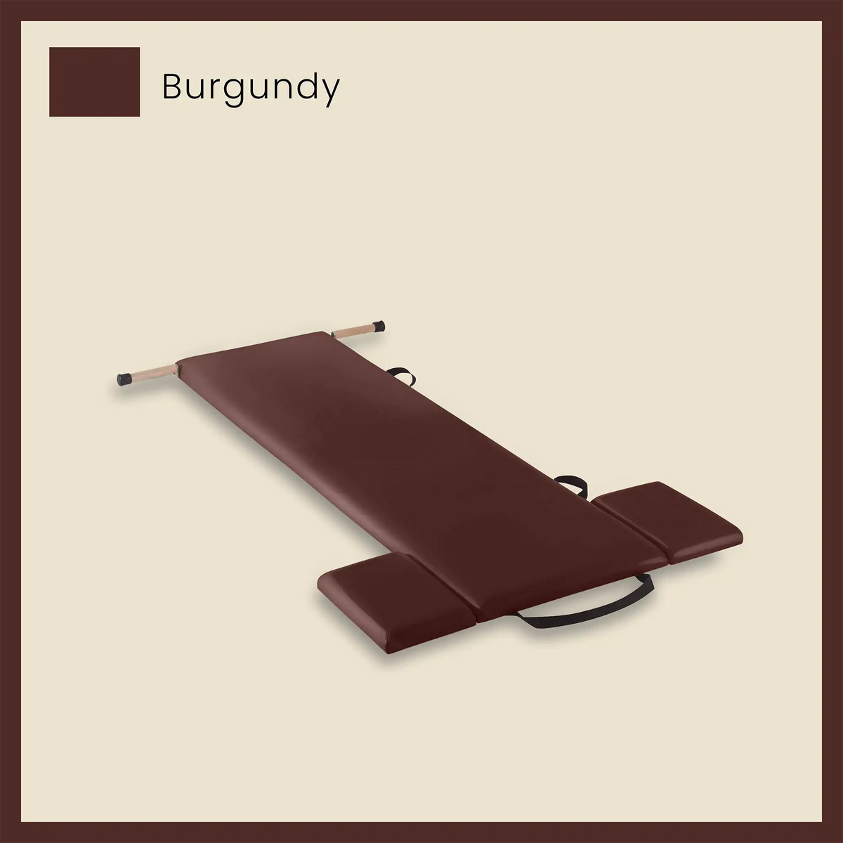 Thick pilates mat in burgundy color with side cushions and foot strap on a neutral beige background.
