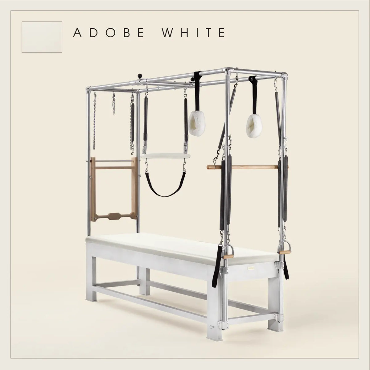 Adobe white color Trapeze Table with aluminum frame, adjustable bars, straps, and springs. Premium Pilates equipment against a beige background.
