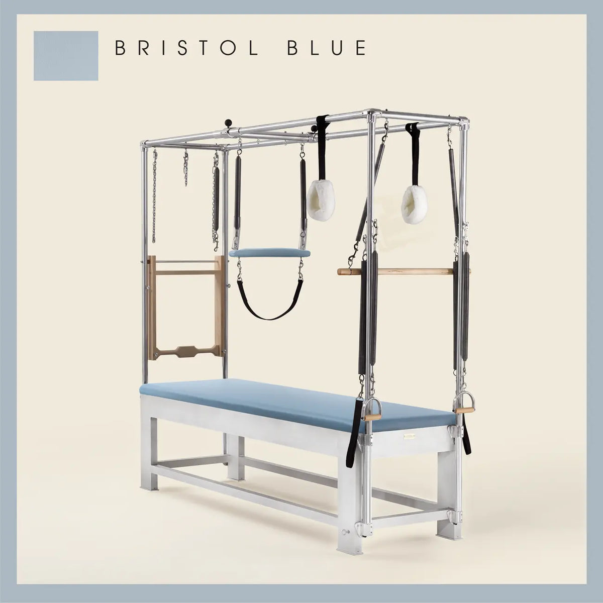 Bristol blue color Trapeze Table with aluminum frame, adjustable bars, straps, and springs. Premium Pilates equipment against a beige background.