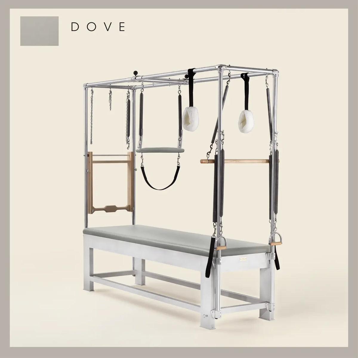Dove color Trapeze Table with aluminum frame, adjustable bars, straps, and springs. Premium Pilates equipment against a beige background.