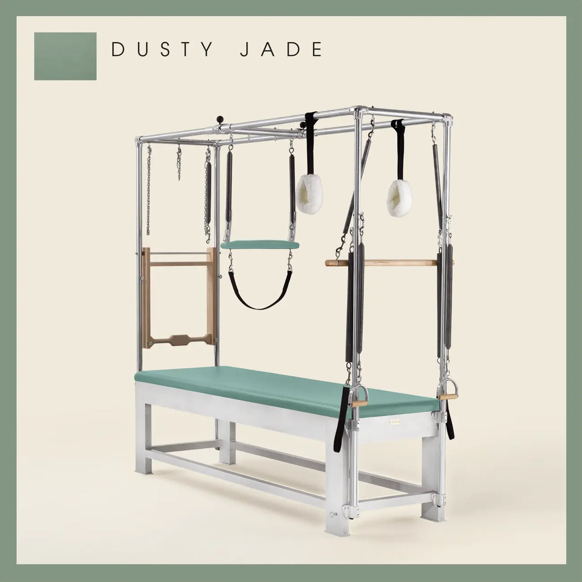 Dusty Jade color Trapeze Table with aluminum frame, adjustable bars, straps, and springs. Premium Pilates equipment against a beige background.