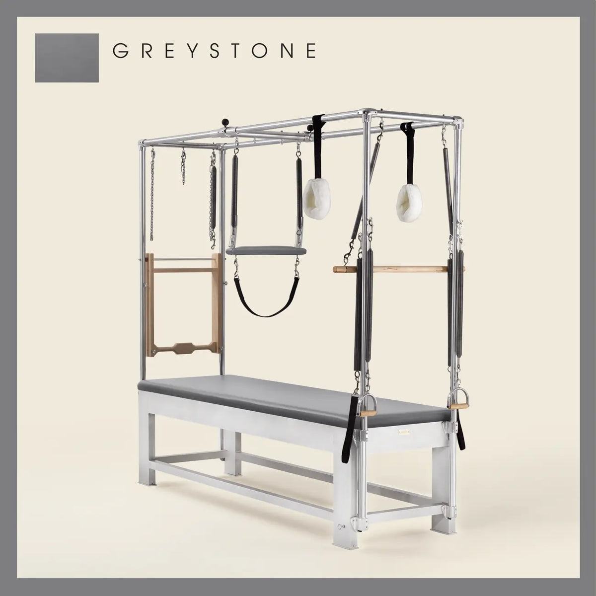 Greystone color Trapeze Table with aluminum frame, adjustable bars, straps, and springs. Premium Pilates equipment against a beige background.