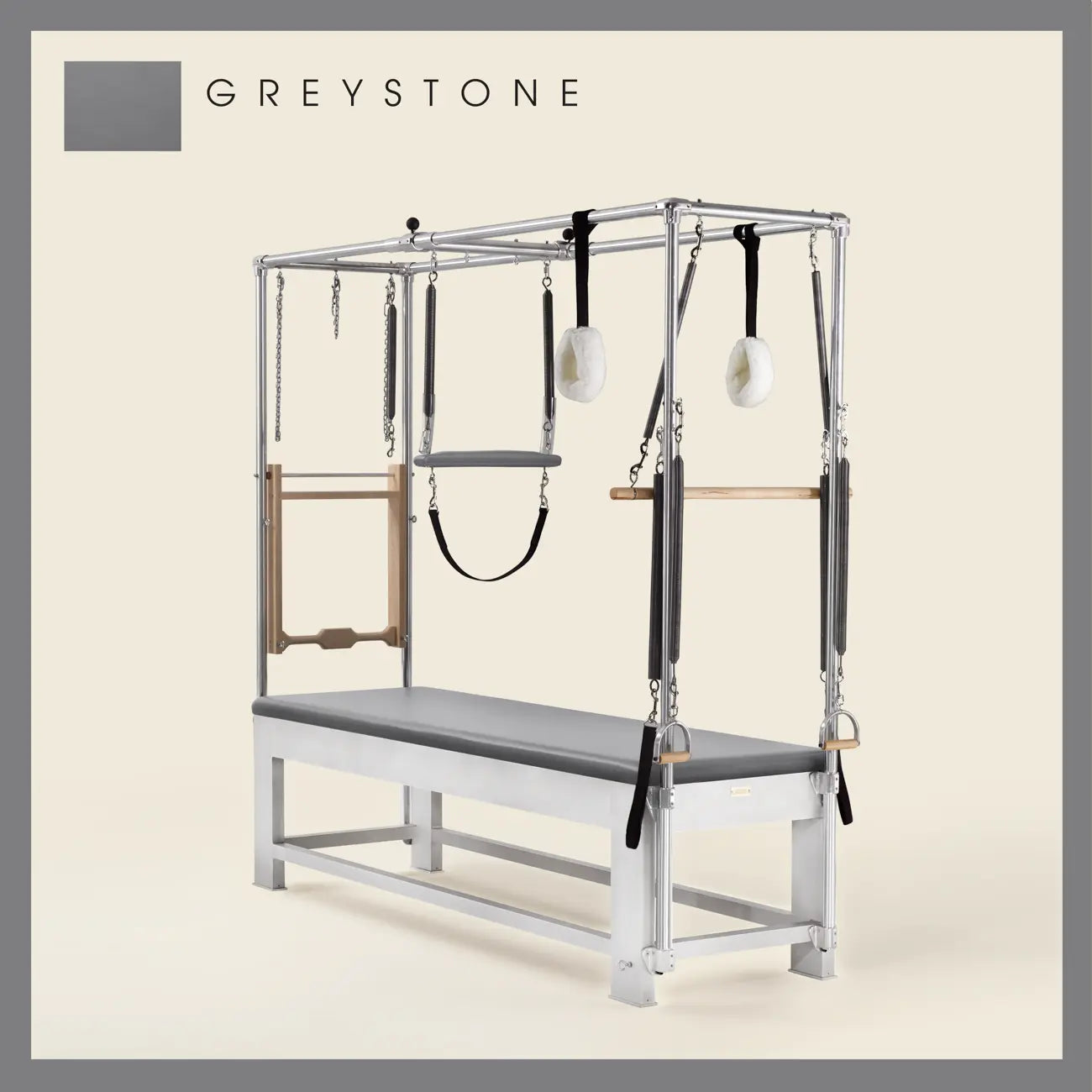 Greystone color Trapeze Table with aluminum frame, adjustable bars, straps, and springs. Premium Pilates equipment against a beige background.
