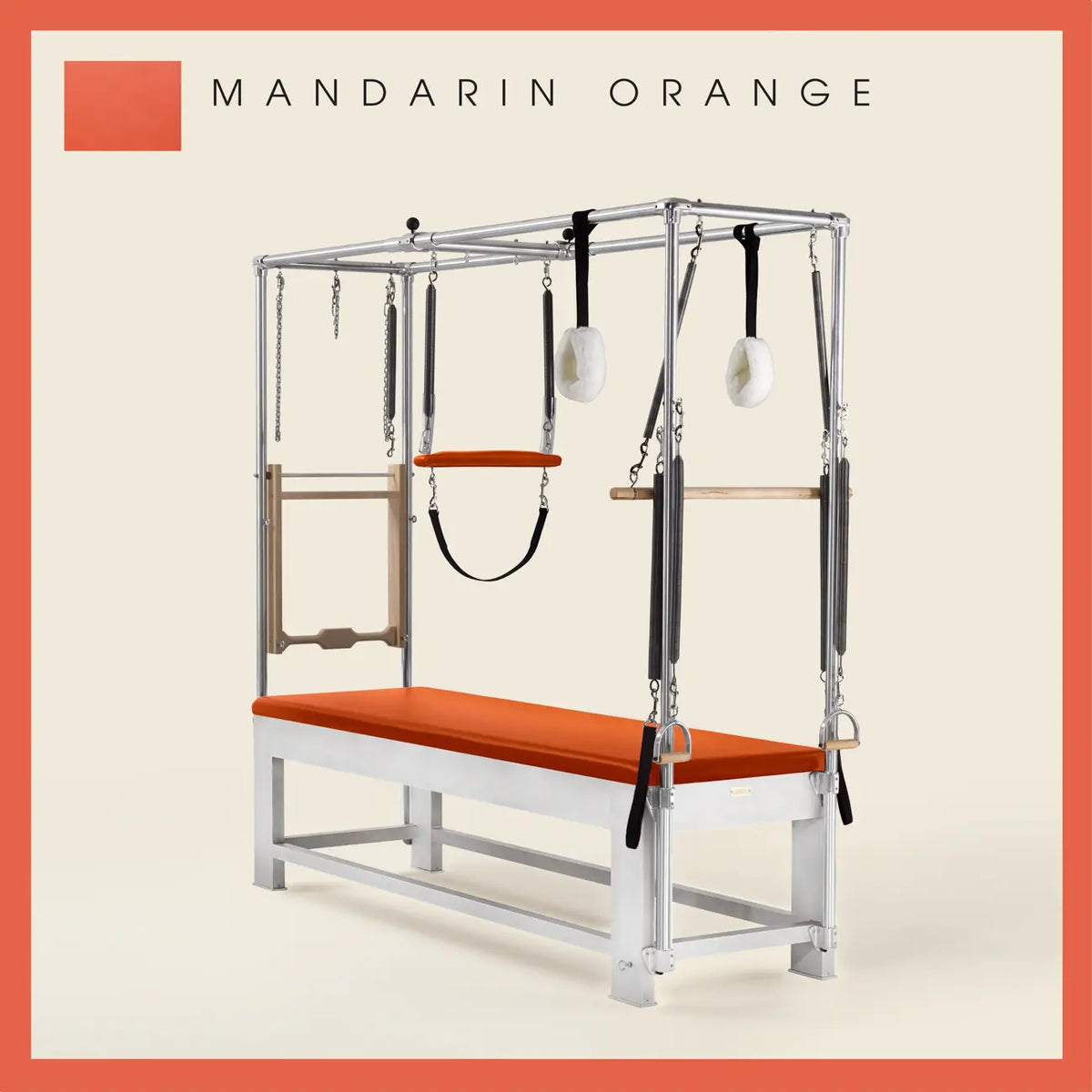Mandarin Orange color Trapeze Table with aluminum frame, adjustable bars, straps, and springs. Premium Pilates equipment against a beige background.