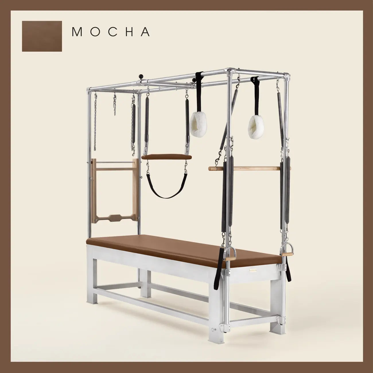 Mocha color Trapeze Table with aluminum frame, adjustable bars, straps, and springs. Premium Pilates equipment against a beige background.
