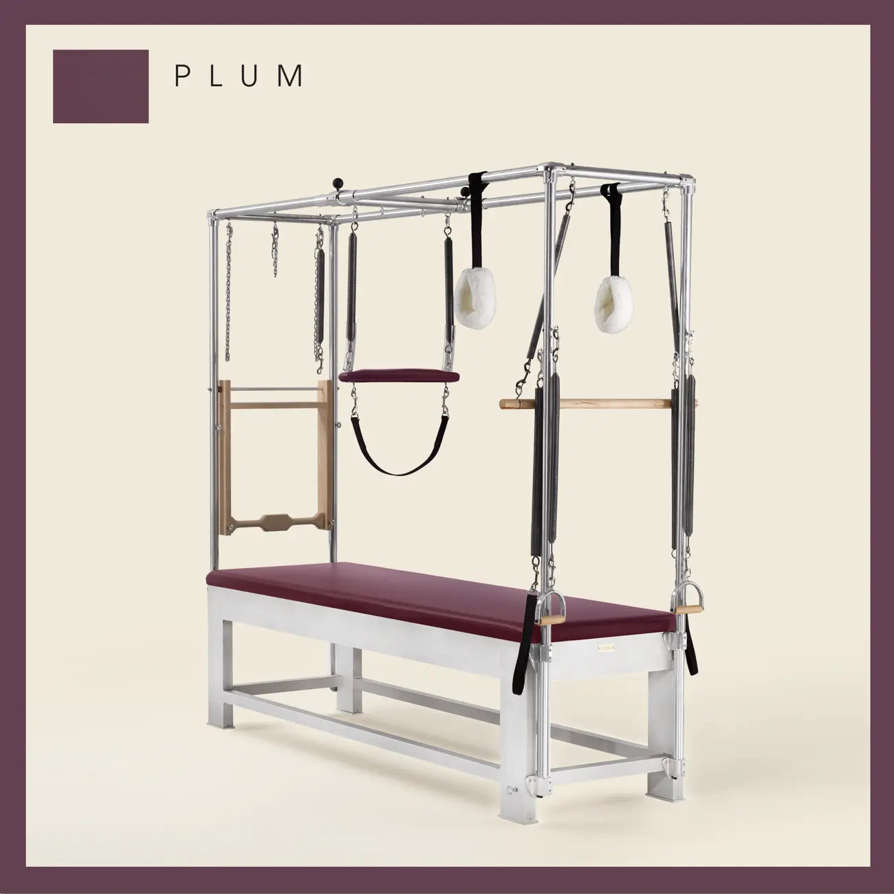 Plum color Trapeze Table with aluminum frame, adjustable bars, straps, and springs. Premium Pilates equipment against a beige background.