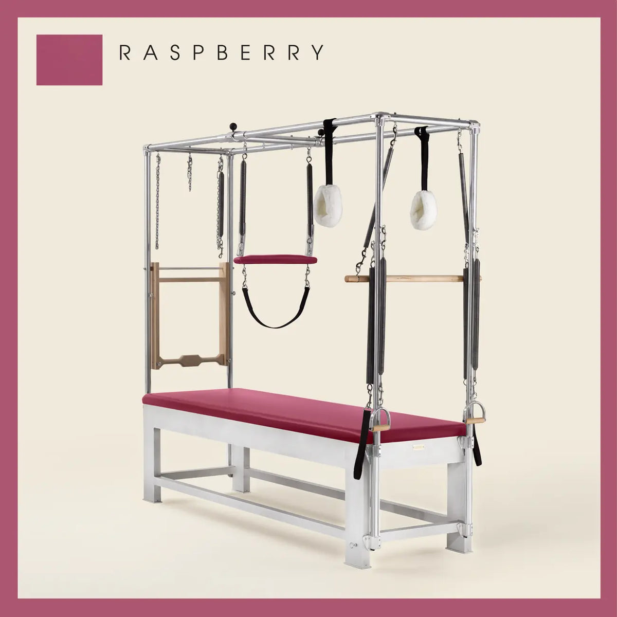 Raspberry color Trapeze Table with aluminum frame, adjustable bars, straps, and springs. Premium Pilates equipment against a beige background.