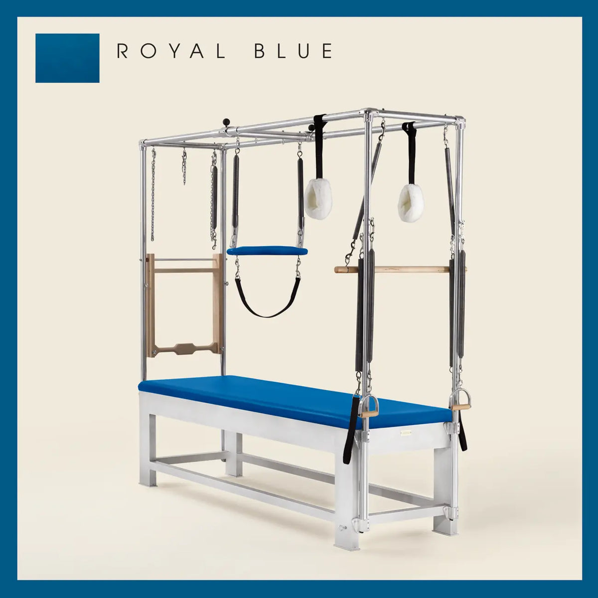 Royal blue color Trapeze Table with aluminum frame, adjustable bars, straps, and springs. Premium Pilates equipment against a beige background.