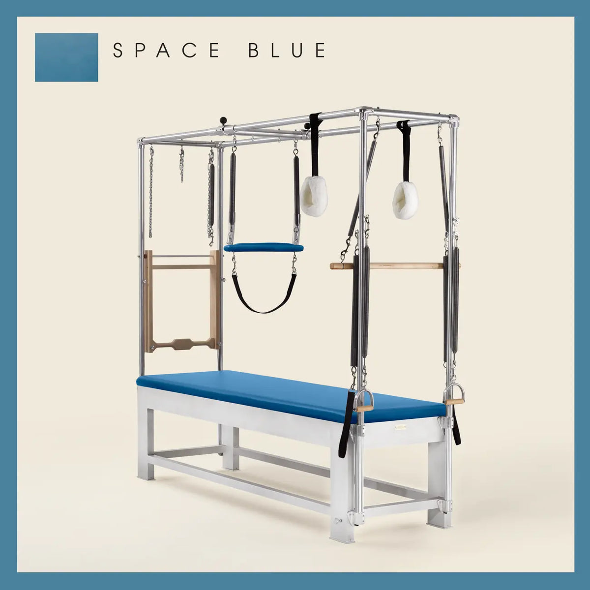 Space Blue color Trapeze Table with aluminum frame, adjustable bars, straps, and springs. Premium Pilates equipment against a beige background.