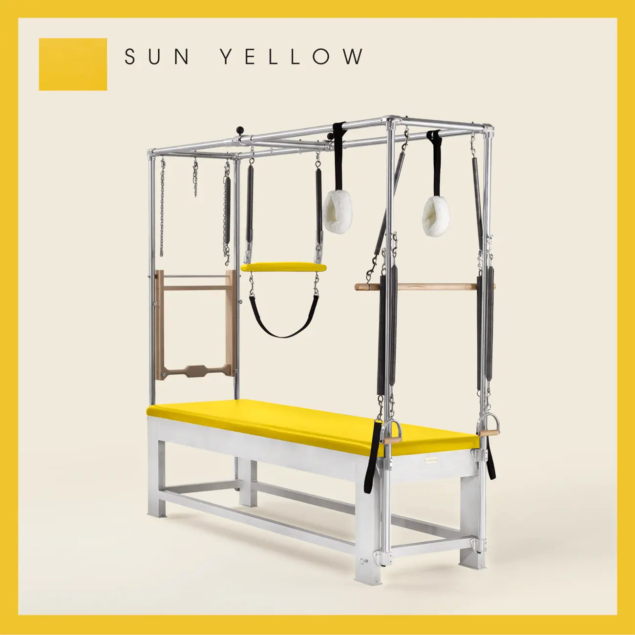 Sun Yellow color Trapeze Table with aluminum frame, adjustable bars, straps, and springs. Premium Pilates equipment against a beige background.