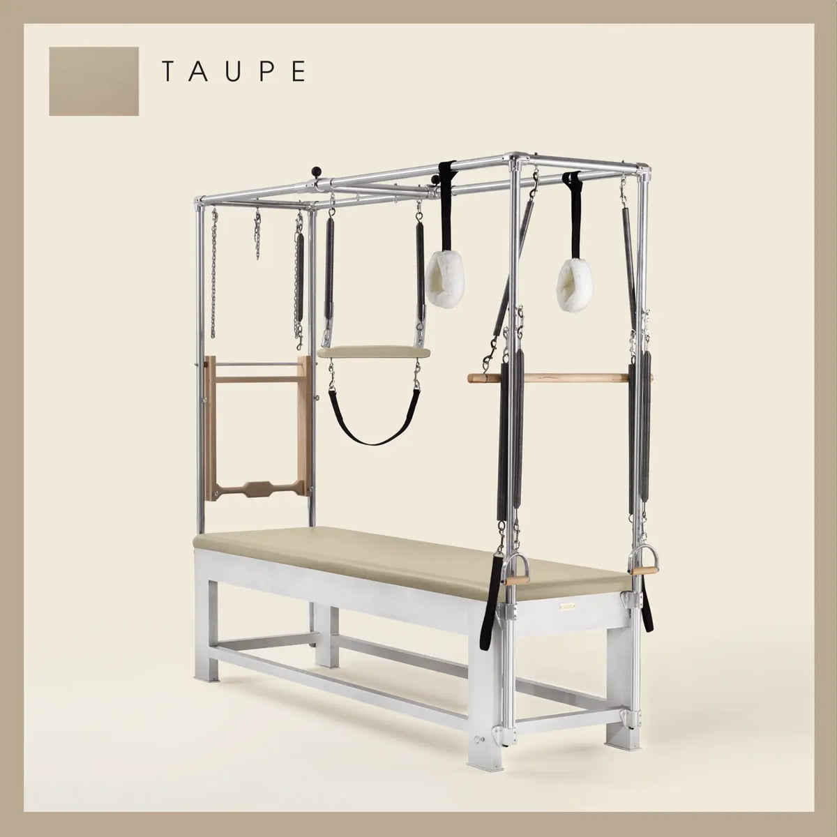 Taupe color Trapeze Table with aluminum frame, adjustable bars, straps, and springs. Premium Pilates equipment against a beige background.
