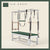 Yew green color Trapeze Table with aluminum frame, adjustable bars, straps, and springs. Premium Pilates equipment against a beige background.