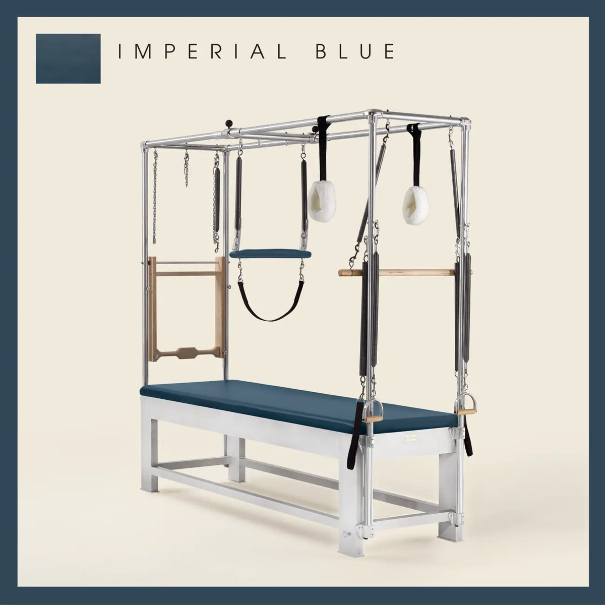 Imperial Blue color Trapeze Table with aluminum frame, adjustable bars, straps, and springs. Premium Pilates equipment against a beige background.