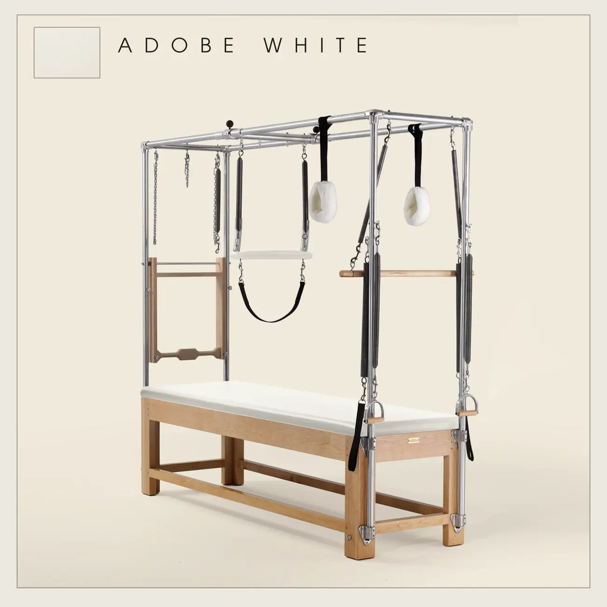 Adobe White ilates Cadillac with maple wood frame, adjustable bars, straps, and springs. Premium Pilates equipment against a beige background.