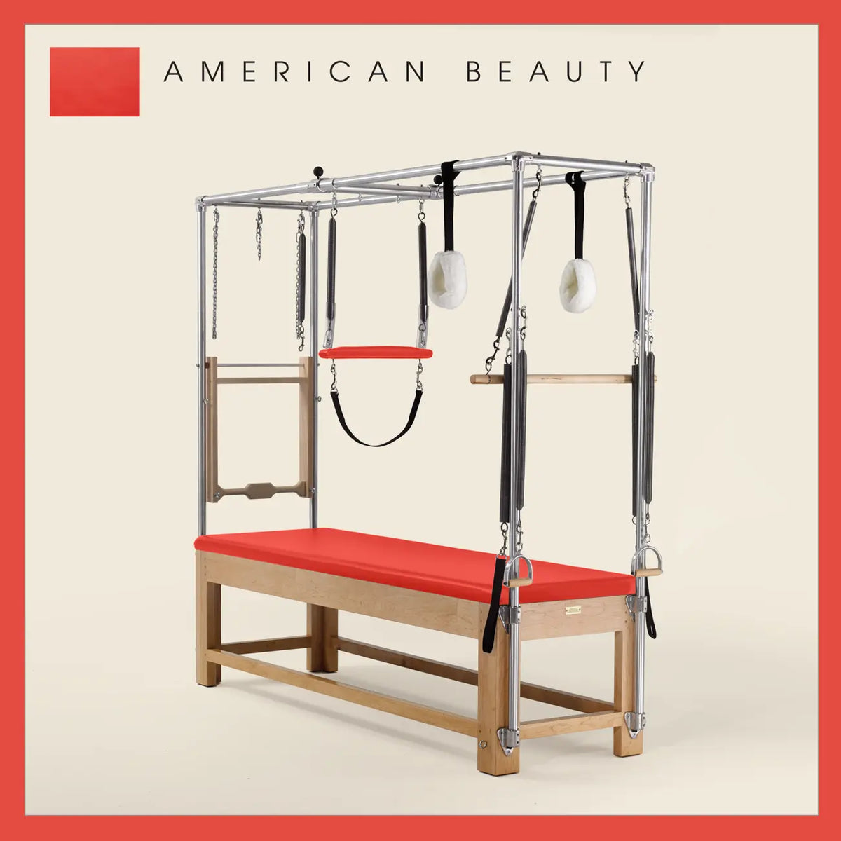 American Beauty color Pilates Cadillac with maple wood frame, adjustable bars, straps, and springs. Premium Pilates equipment against a beige background.
