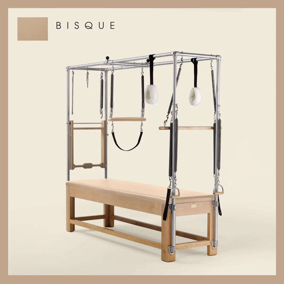 Bisque color Pilates Cadillac with maple wood frame, adjustable bars, straps, and springs. Premium Pilates equipment against a beige background.