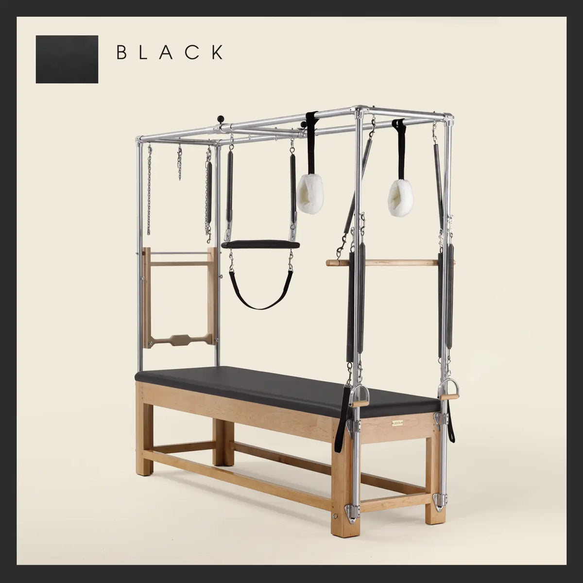 Black Pilates Cadillac with maple wood frame, adjustable bars, straps, and springs. Premium Pilates equipment against a beige background.