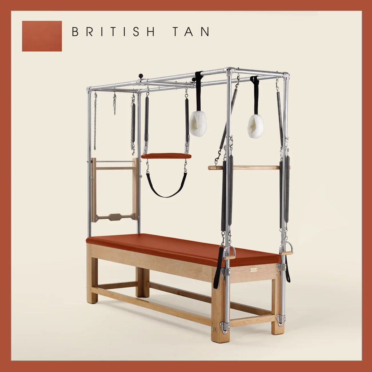 British Tan Pilates Cadillac with maple wood frame, adjustable bars, straps, and springs. Premium Pilates equipment against a beige background.